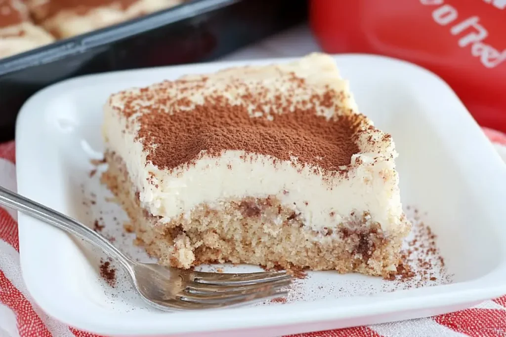 Cinnamon roll poke cake on a plate with a fork.