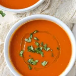 Person enjoying spicy tomato soup and grilled cheese.