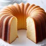 Overhead view of a classic pound cake with berries and powdered sugar.